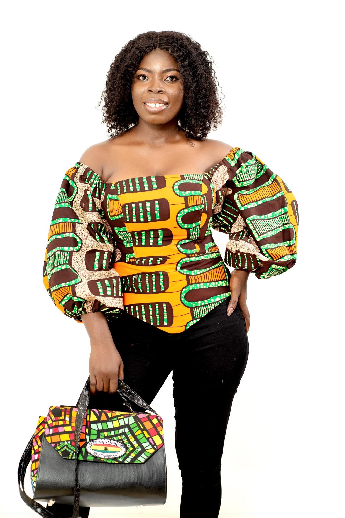 Patricia Quaye in a colorful top from SHE 4 Change featuring traditional African prints and matching handbag